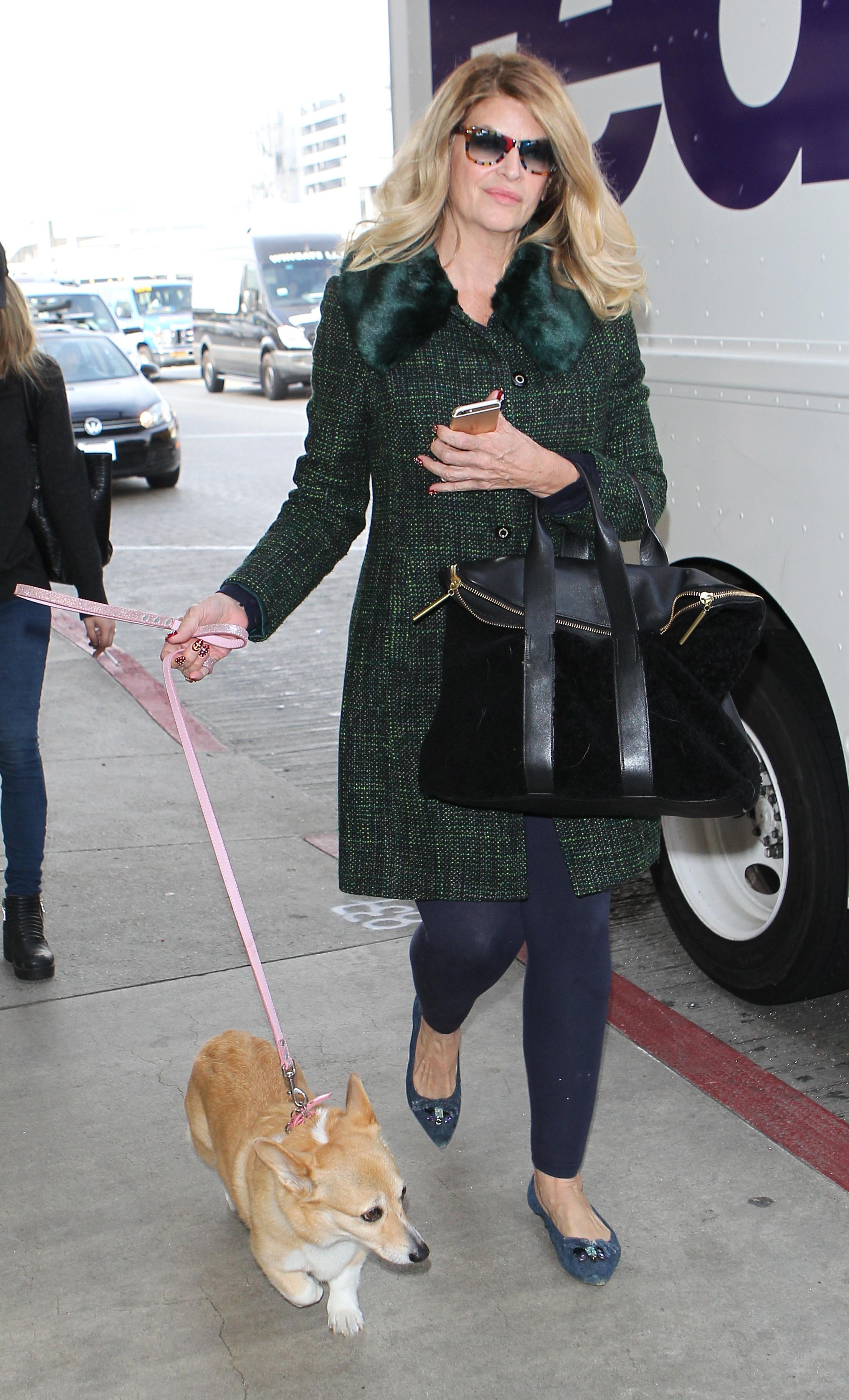 Kirstie Alley arrives for a flight with her dog by her side