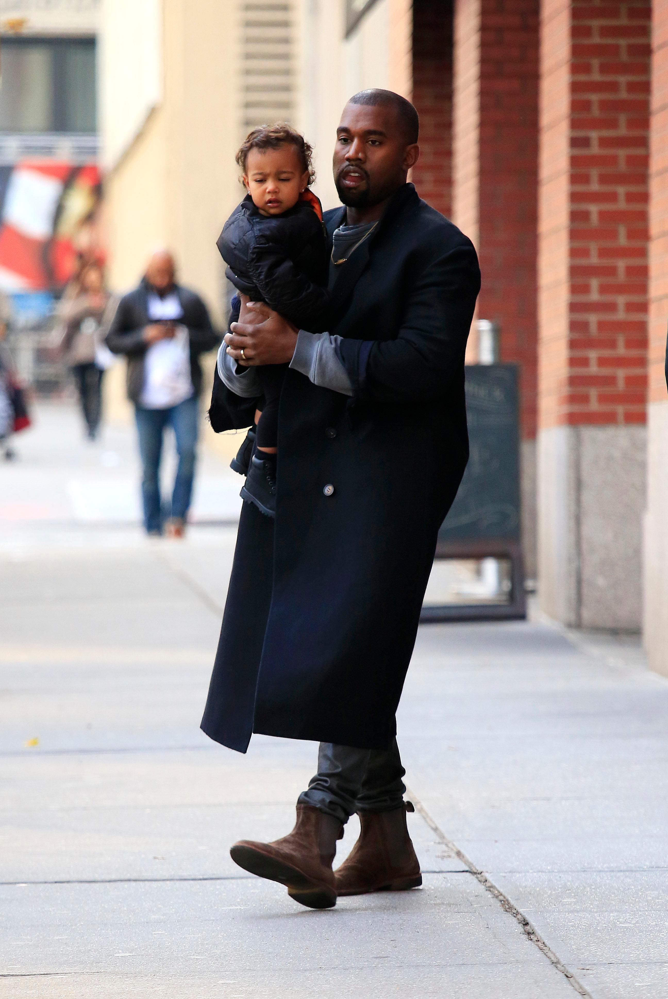 EXCLUSIVE: Kanye West carries baby daughter North West in SoHo, New York City