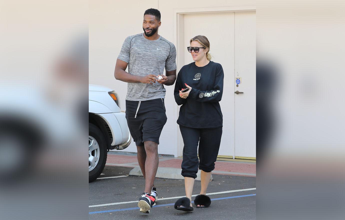 A barefaced Khloe Kardashian stops to take a photo with a fan after a laser session