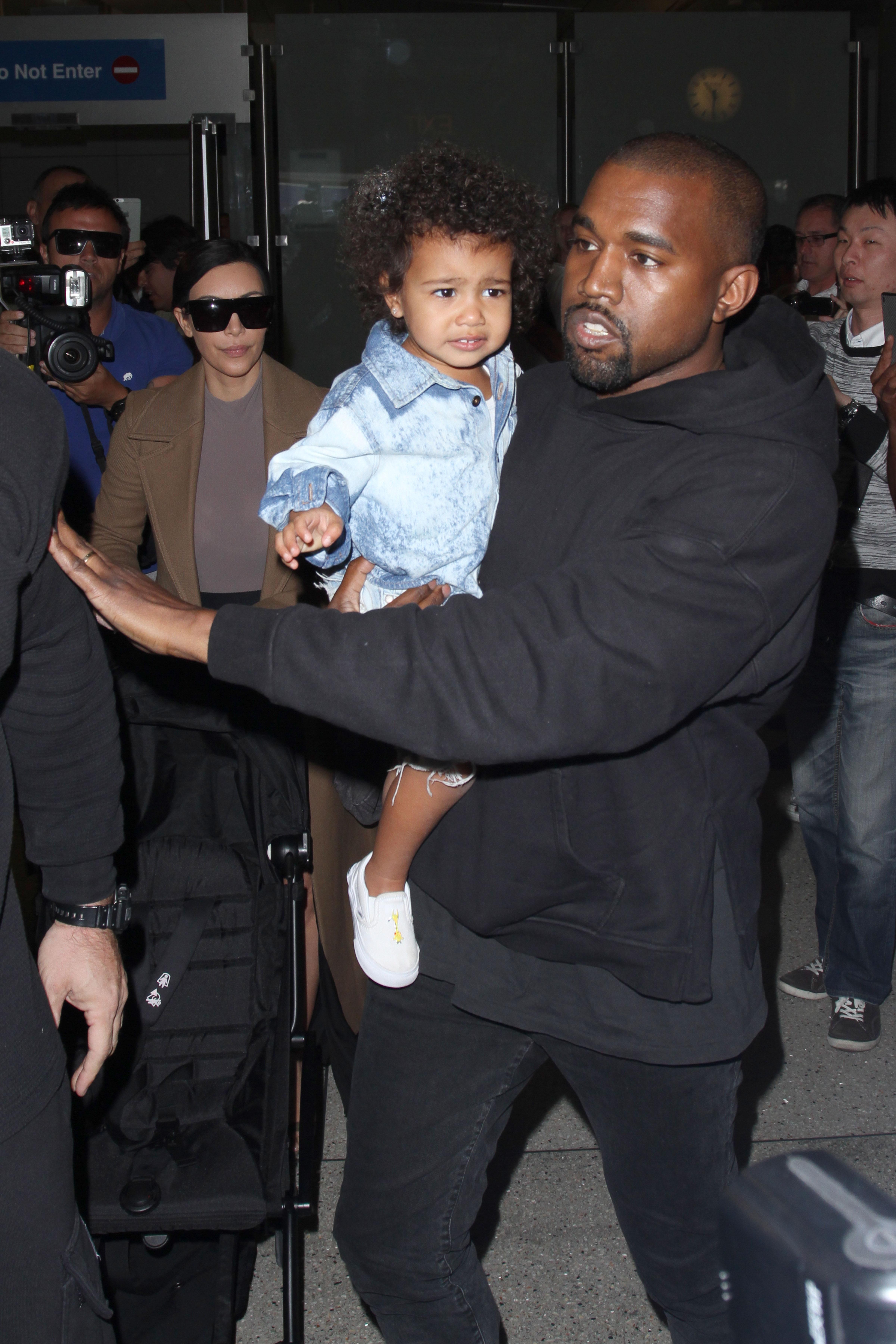 Kim Kardashian, Kanye West &amp; North West arrive in Los Angeles as they rush to a waiting SUV only seconds before a process server serves West with legal papers.