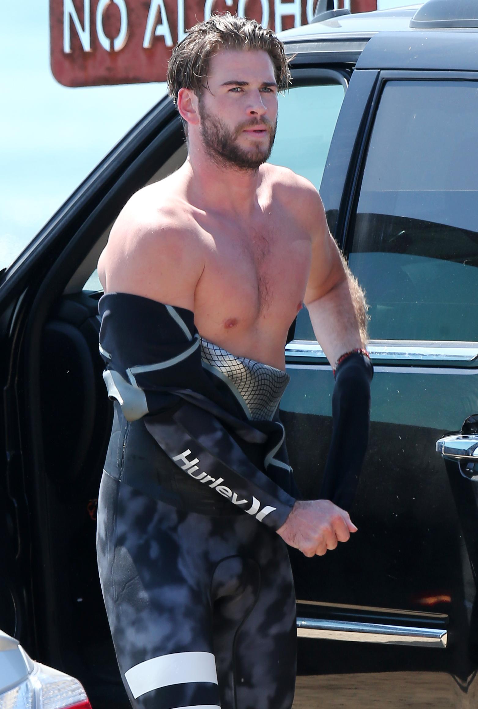 EXCLUSIVE: Liam Hemsworth showing off his muscles as he surfs with a friend in Malibu