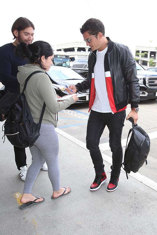 Orlando Bloom signs autographs arriving at LAX