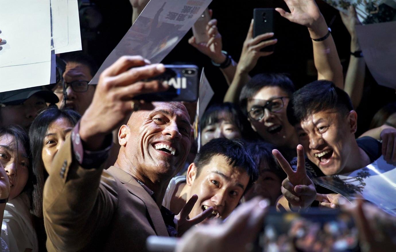 The Rock takes a selfie with adoring fans on the red carpet.