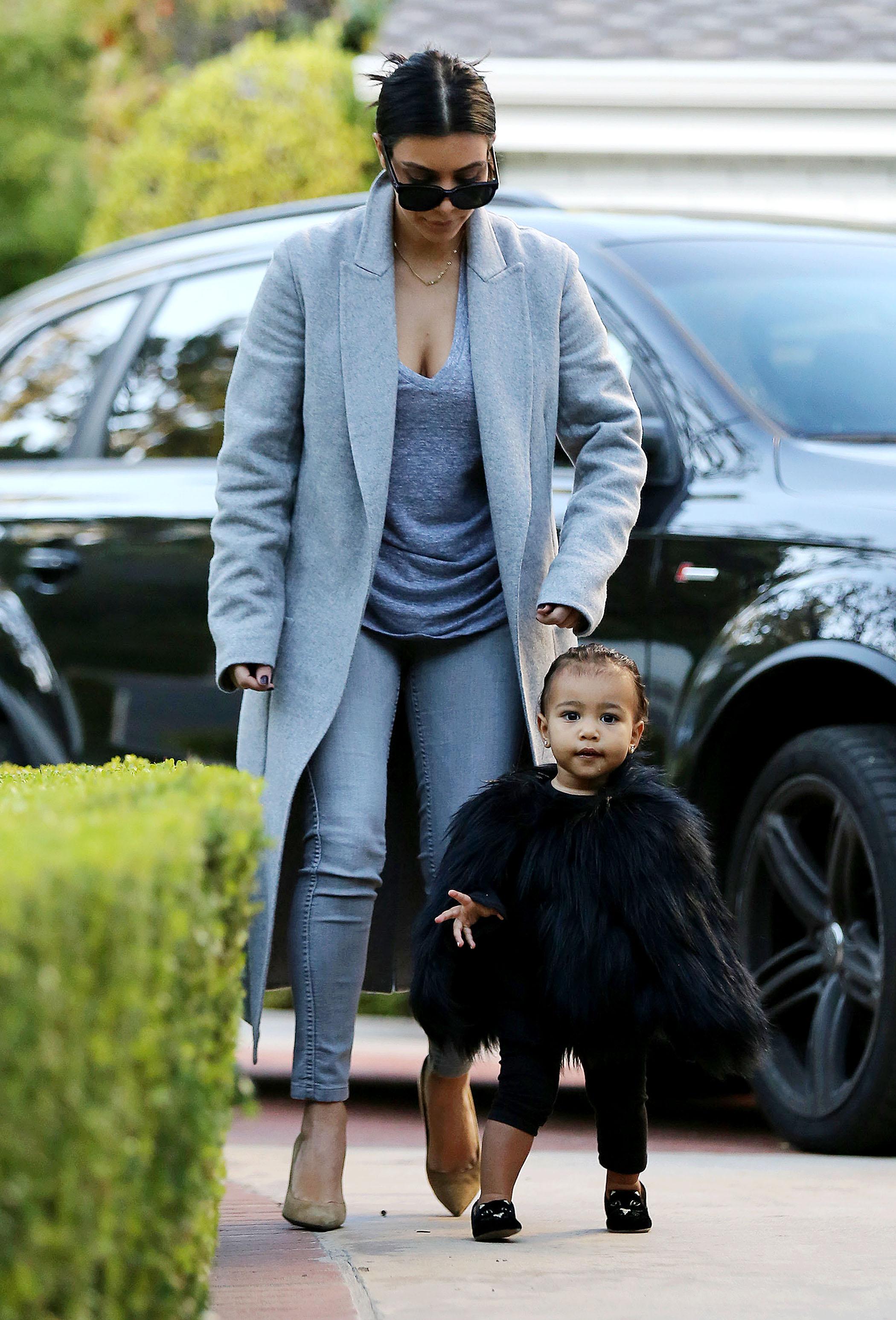 Kim Kardashian and her baby North, dressed in a black fur cape, arriving at a friend&#8217;s house in Beverly Hills ****NO DAILY MAIL SALES****