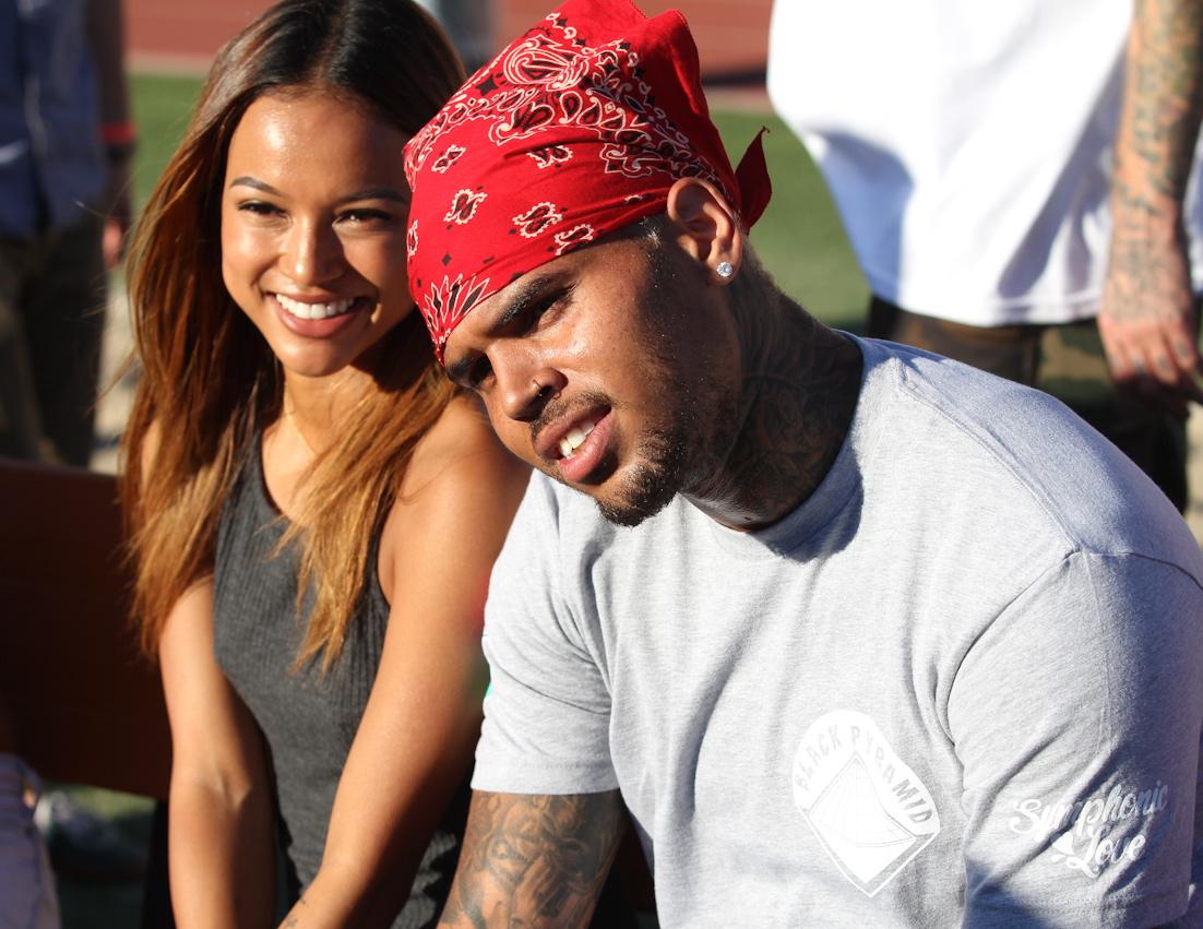 Chris Brown cuddles up to on/off girlfriend Karrueche Tran as they attend his charity footbal game in Los Angeles, CA