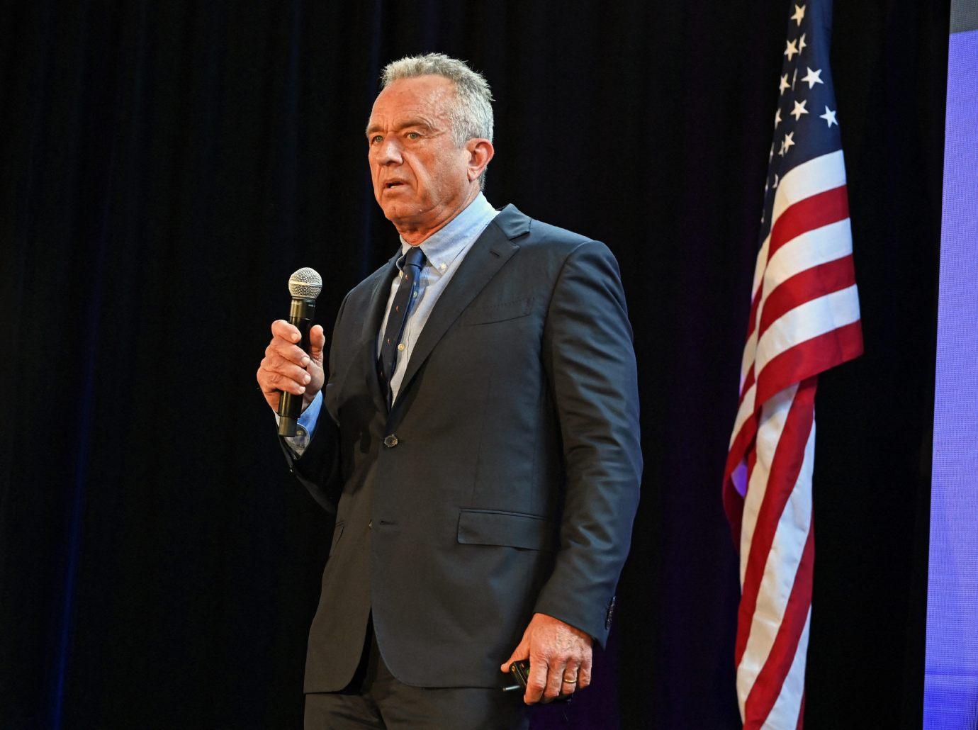 Photo of Robert F. Kennedy Jr. in a black suit holding a microphone.