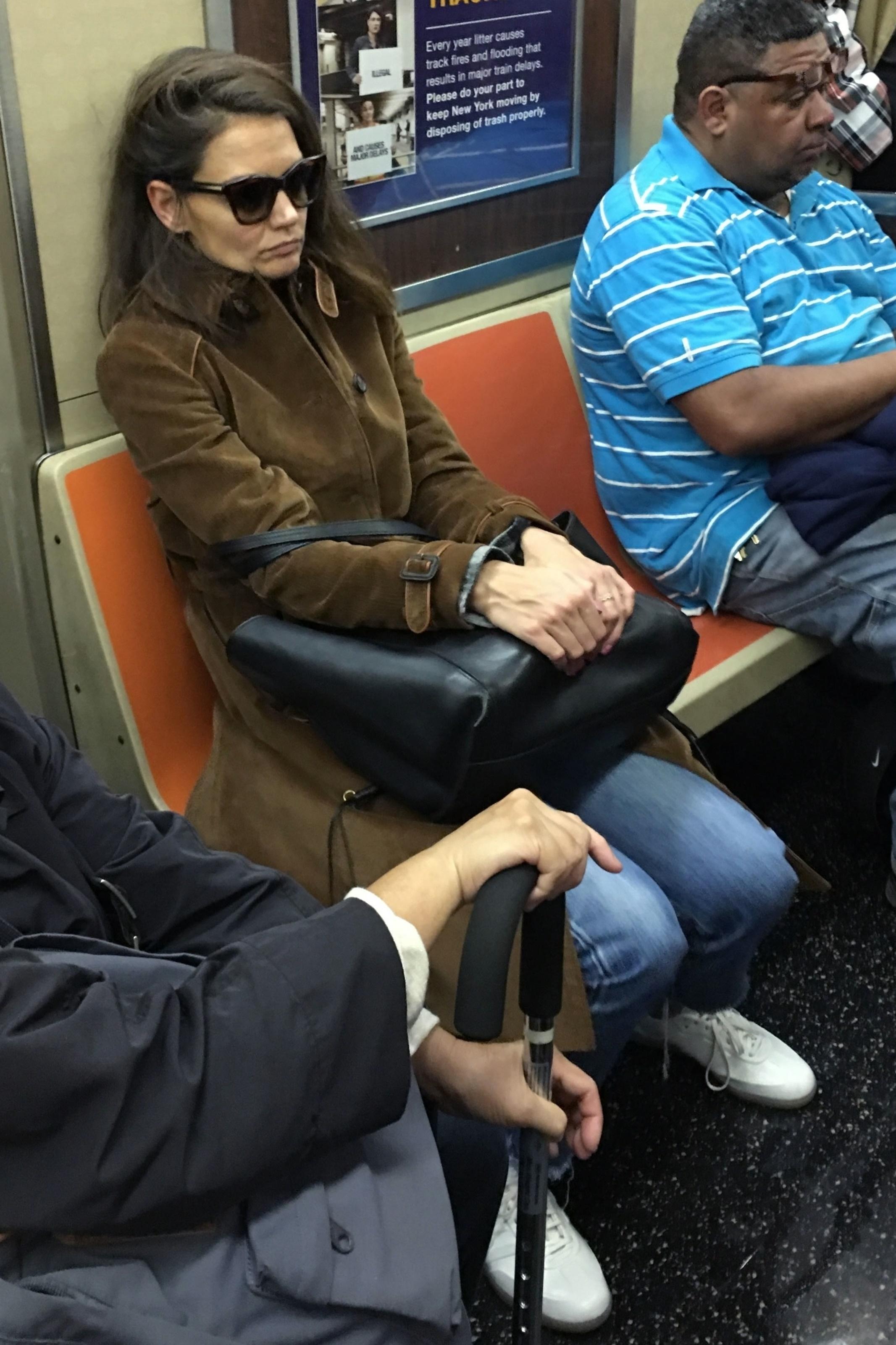 Katie Holmes rides a crowded subway train in NYC