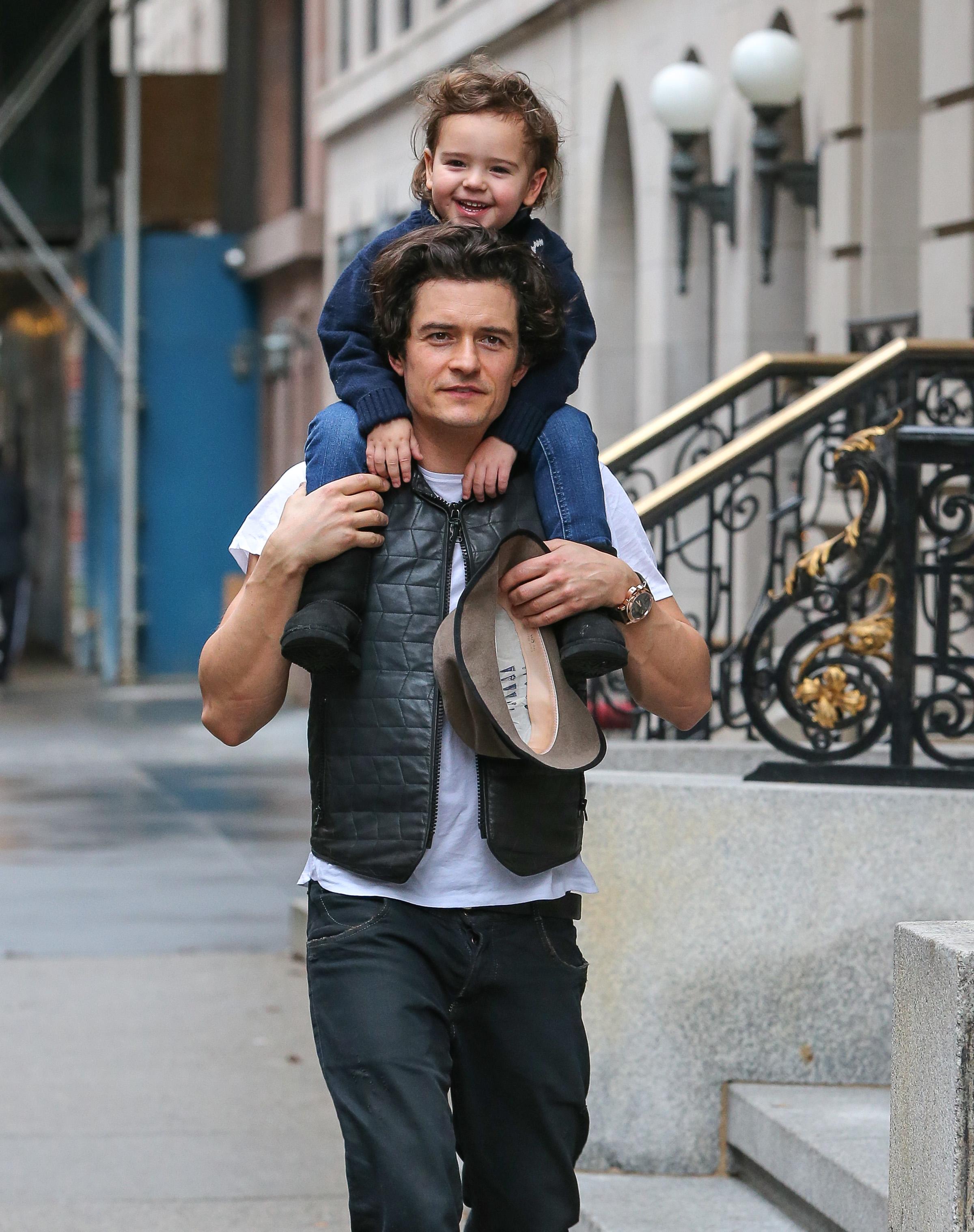 Orlando Bloom takes son Flynn to enjoy a ride on his shoulders during a walk in New York City