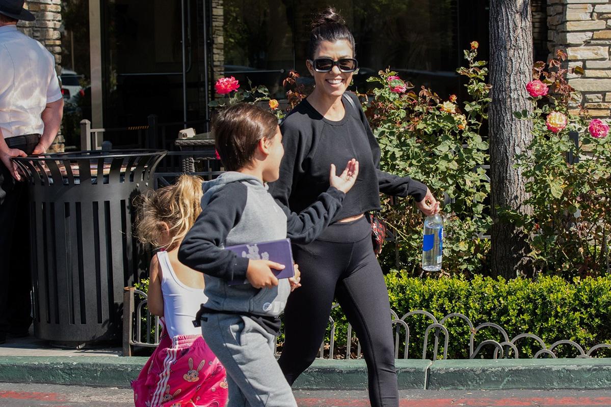 Kourtney Kardashian takes her kids to the movies while Scott Disick lives it up in London