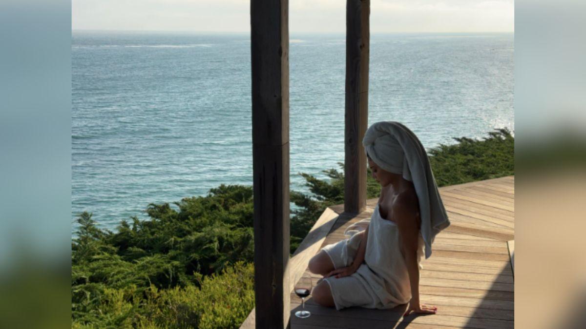Image of Kylie Jenner wore only a towel while sitting outside on the deck.