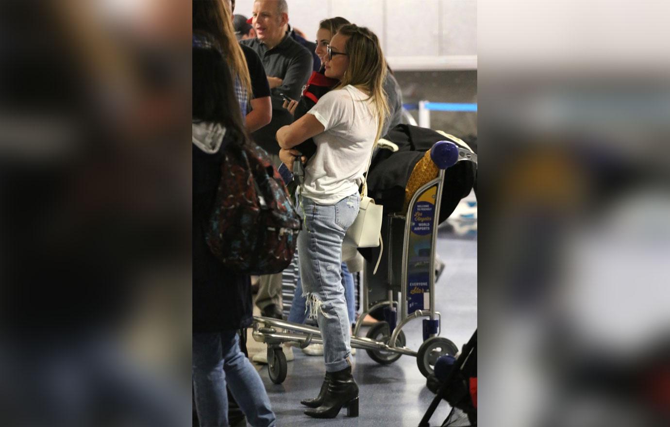 Hilary Duff boards her flight with an adorable puppy at LAX