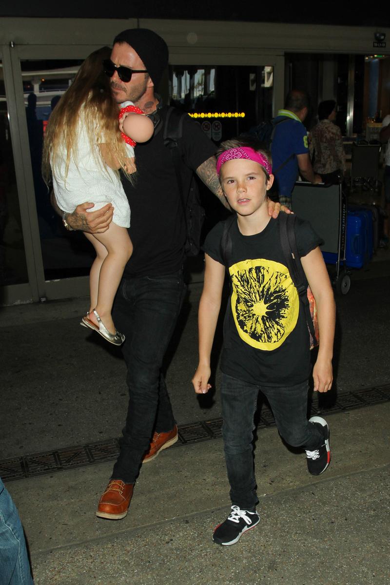 David Beckham carries a sleeping Harper as Romeo gives stylish mum