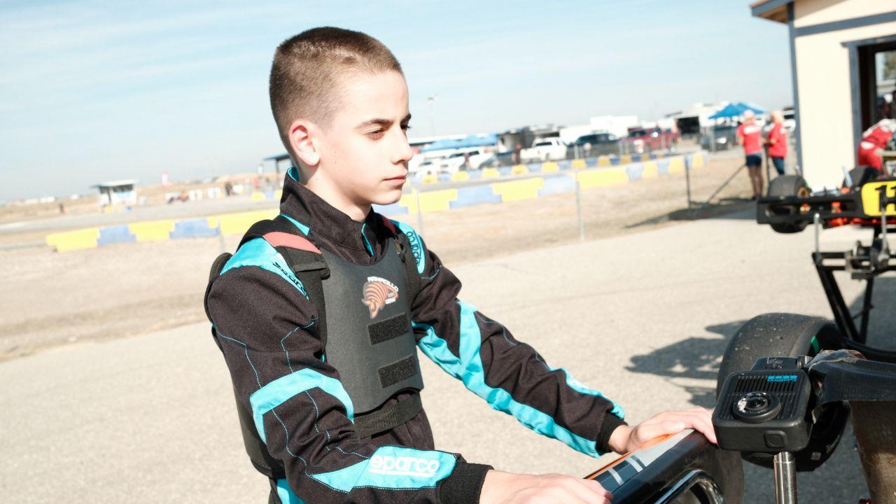 Image of The teenager suited up in a blue helmet and red gloves before getting behind the wheel.