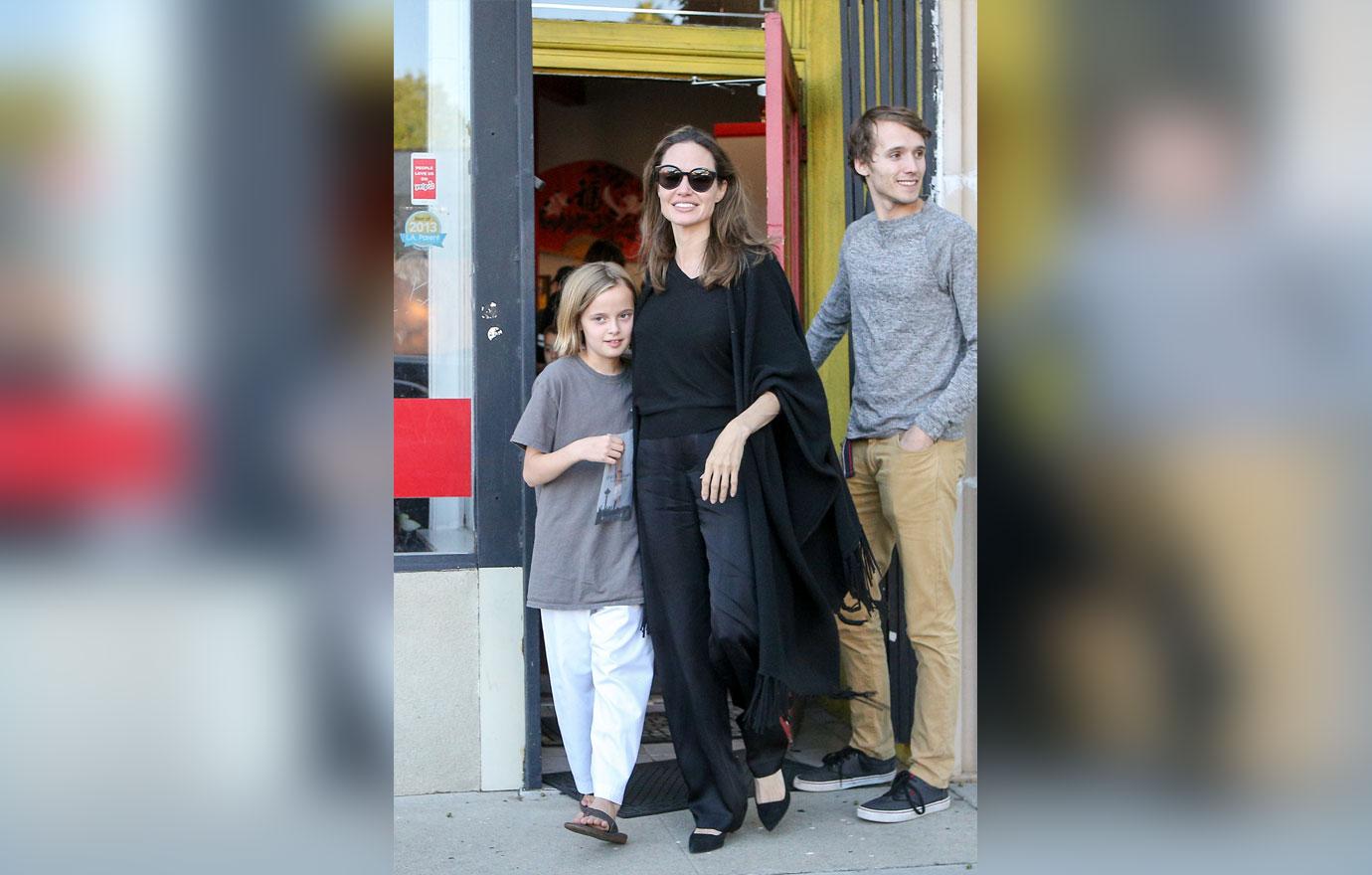 Angelina Jolie is every inch the proud parent as she escorts daughter Vivienne to her karate graduation.