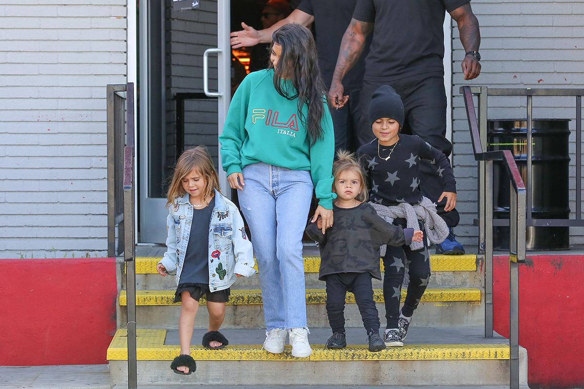 Kourtney Kardashian grins from ear to ear as she leaves the bowling alley with her family