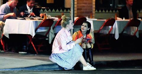 EXCLUSIVE: Elle Fanning sits on a curb and chats with a friend after dinner at Little Dom’s in Los Feliz, CA.