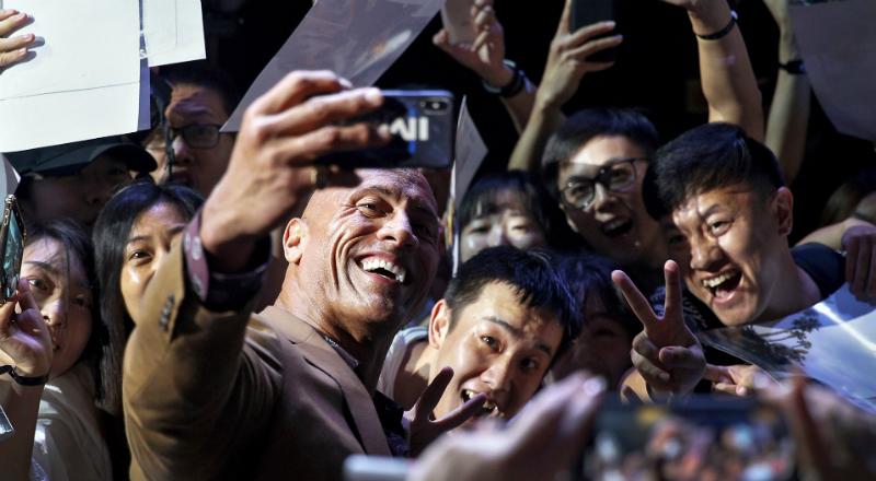 The Rock takes a selfie with adoring fans on the red carpet.