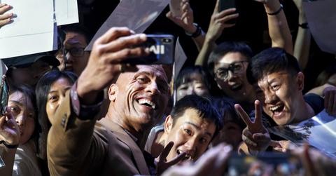 The Rock takes a selfie with adoring fans on the red carpet.