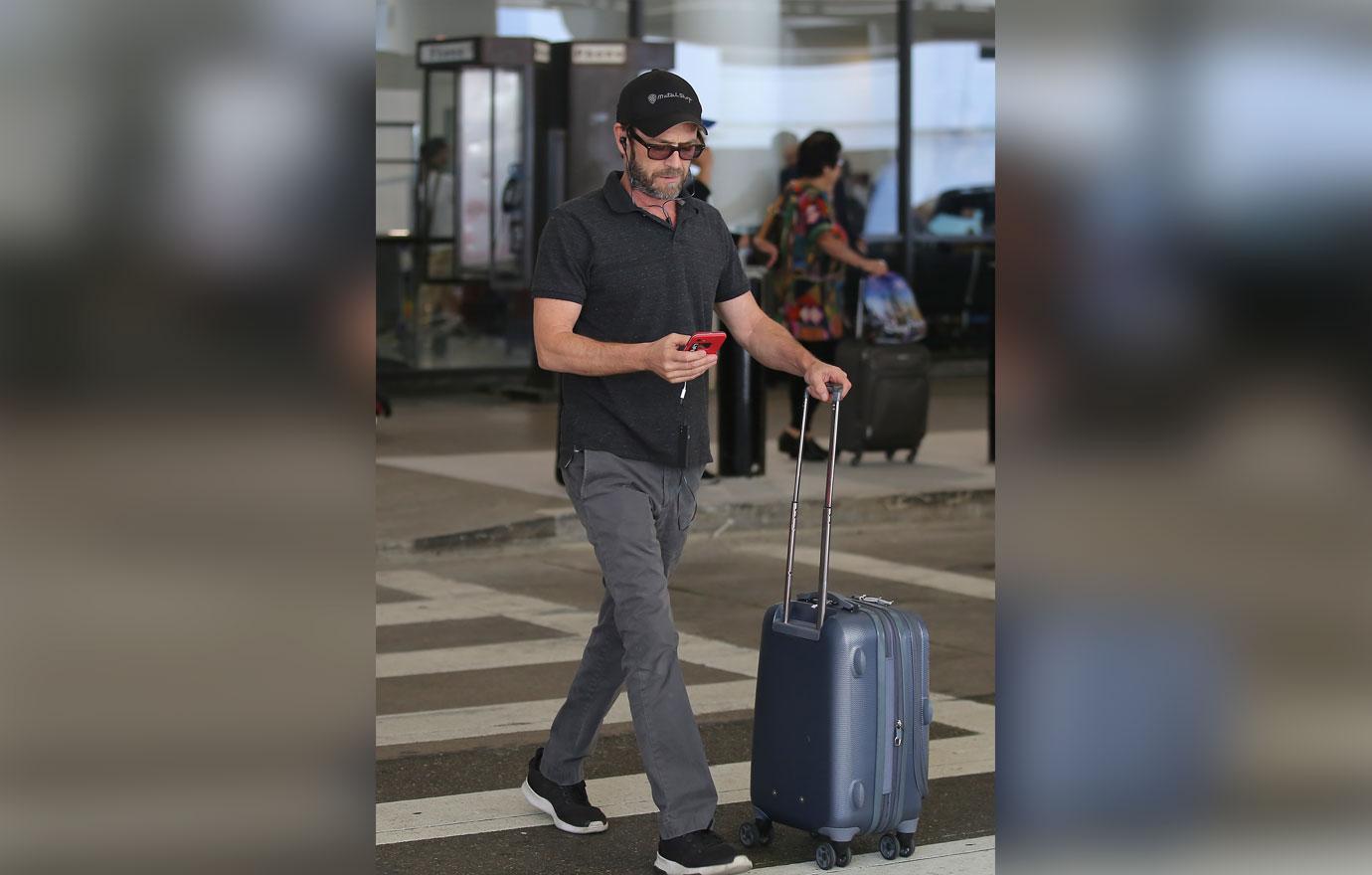 EXCLUSIVE: Luke Perry carries his own luggage at LAX airport