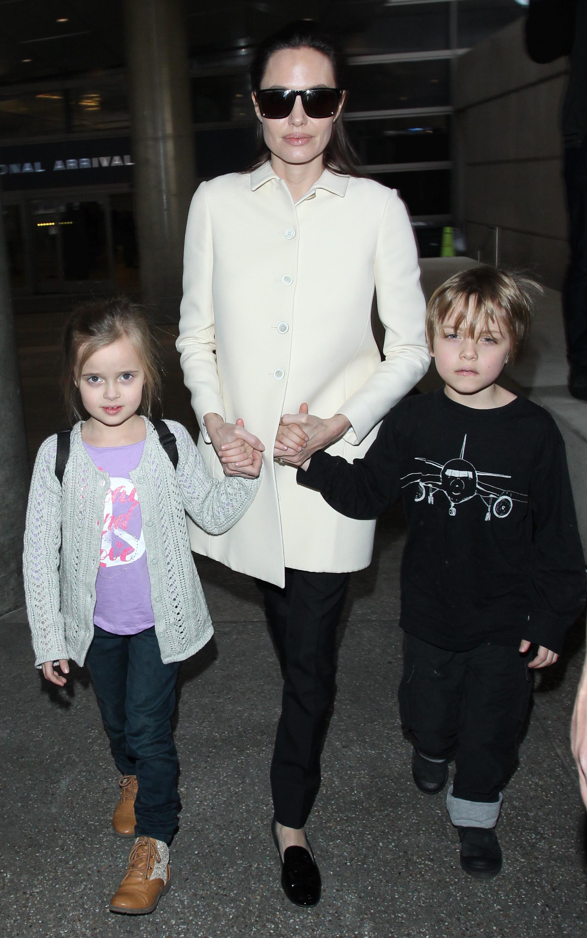 Angelina Jolie and her youngest children twins Knox and Vivienne walk hand in hand as they arrive at LAX Airport in Los Angeles, Ca