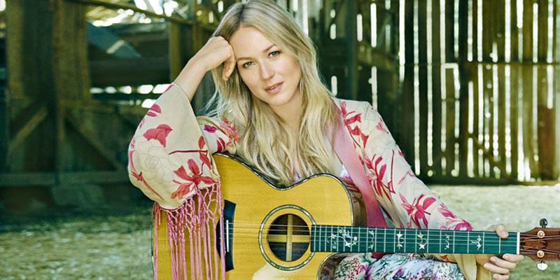 Jewel Sitting with a Guitar on a Chair in a Barn