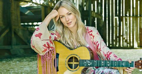 Jewel Sitting with a Guitar on a Chair in a Barn
