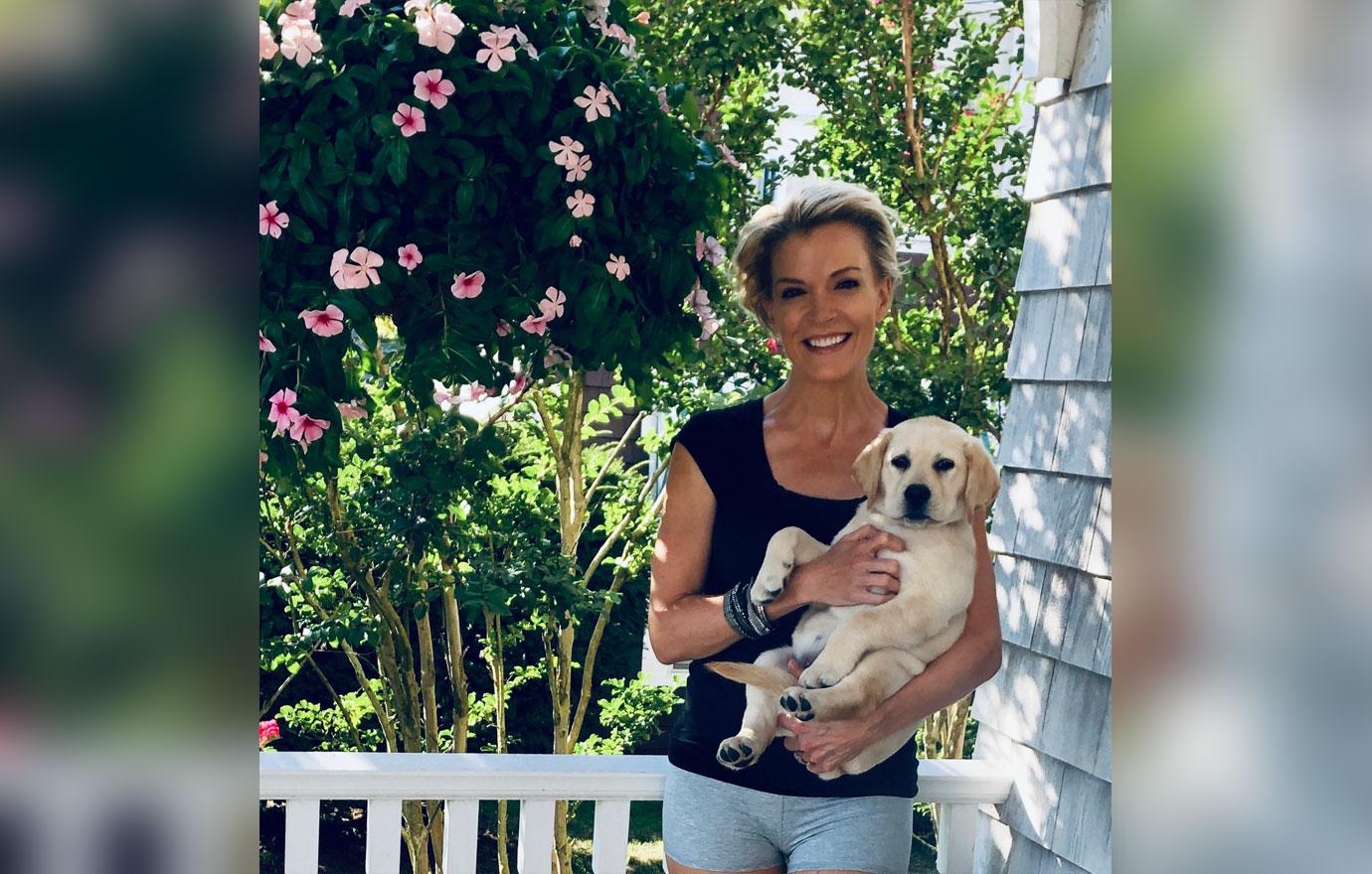 Megyn Kelly Standing on Porch Wearing Navy top and Gray Shorts Holding New Puppy