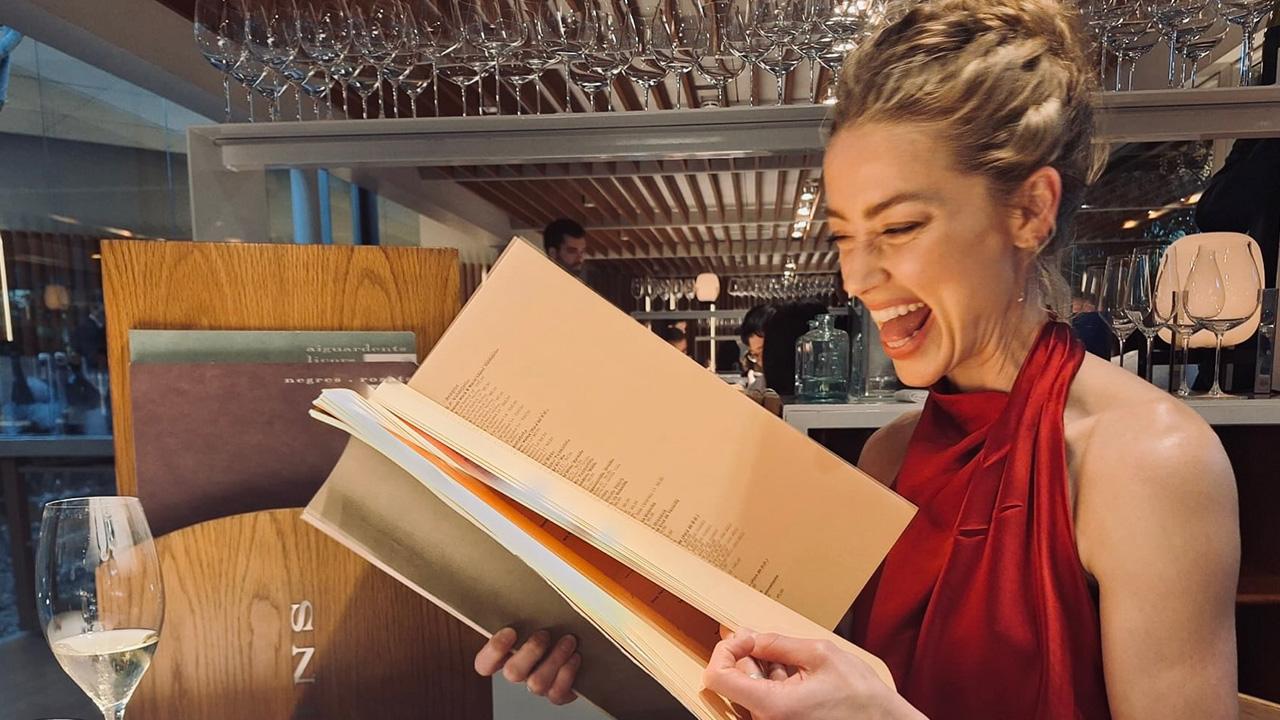 Image of Amber Heard sat down in a restaurant for the snap.