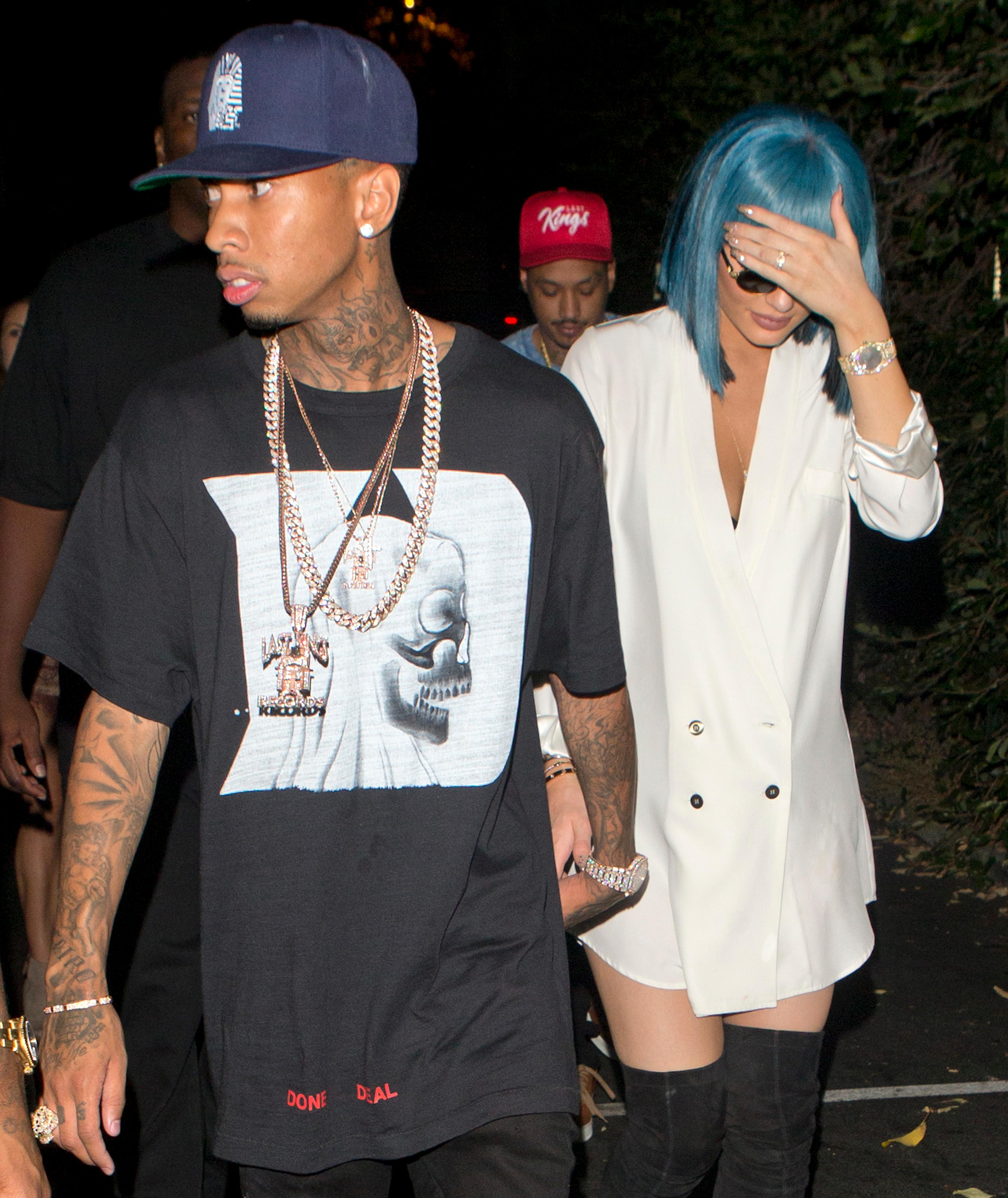 Kylie Jenner with bright Blue hair wearing a white shirt and knee high boots and sunglasses seen holding hands with her boyfriend Tyga leaving &#8216;1 Oak&#8217; Night Club in West Hollywood, CA