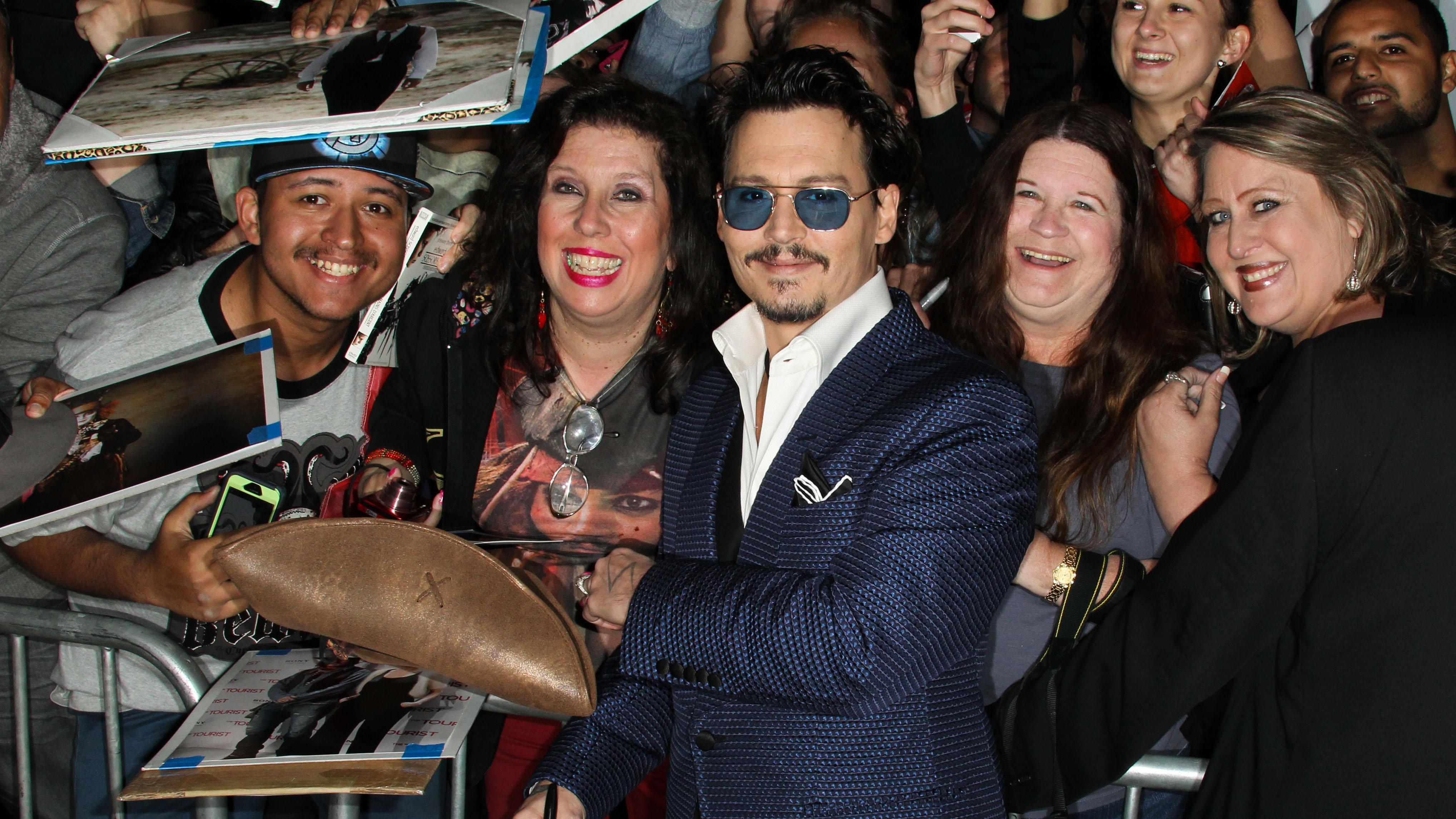 Johnny Depp signs autographs for fans as he arrives at the Los Angeles Premiere Of Warner Bros. Pictures And Alcon Entertainment&#8217;s &#8220;Transcendence&#8221;