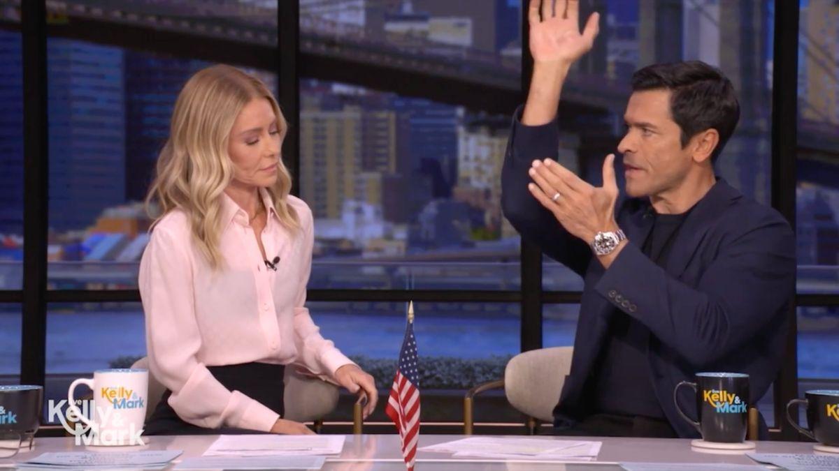 Image of Mark Consuelos reenacted how he places his luggage overhead on a flight.