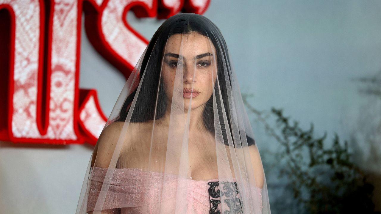 image of Charli XCX rolled around on the hotel bed while celebrating with Madonna and Julia Garner.