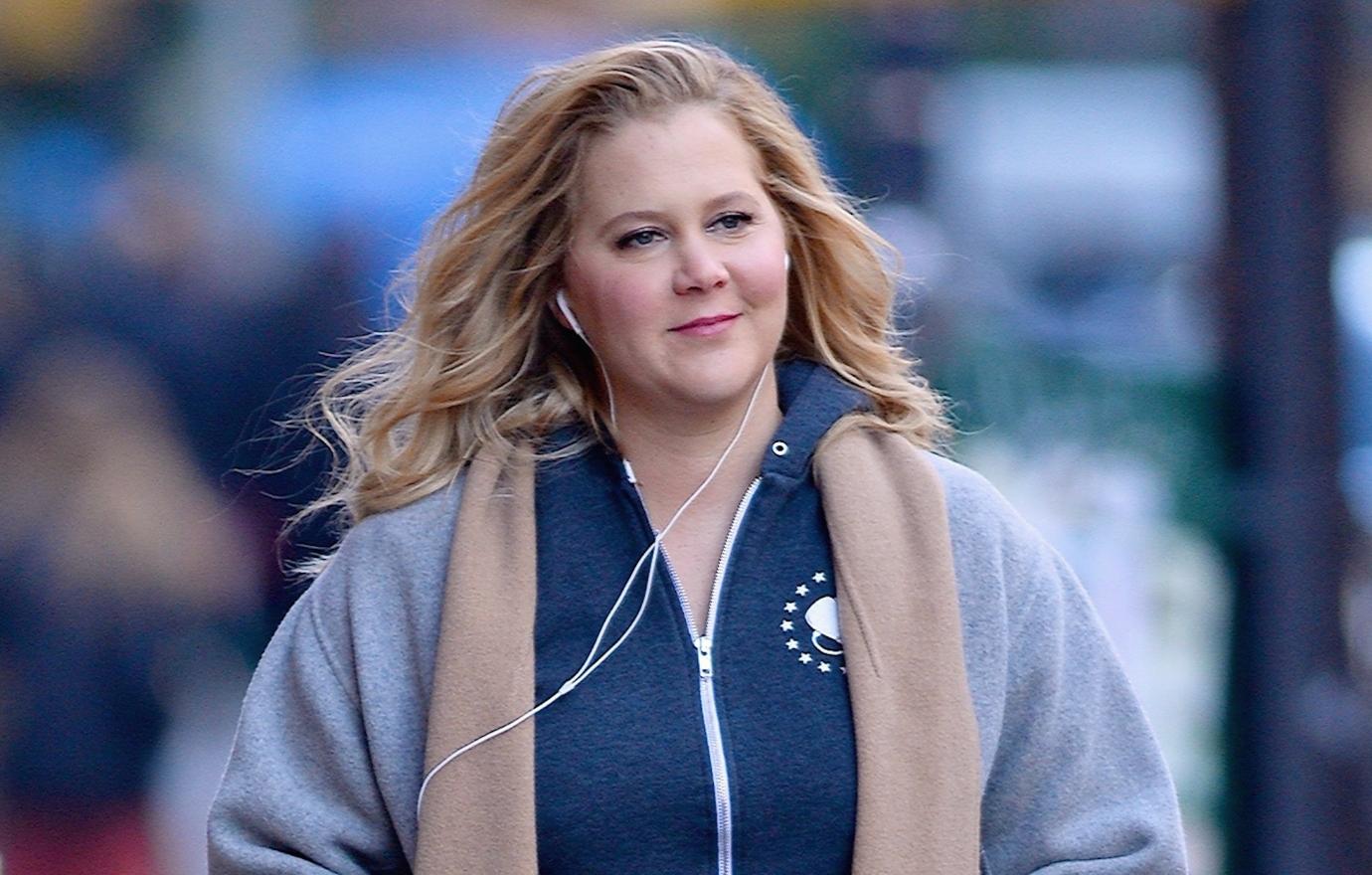 Amy Schumer walking down an NYC street in a heavy coat