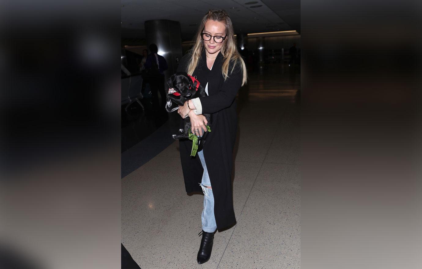 Hilary Duff boards her flight with an adorable puppy at LAX