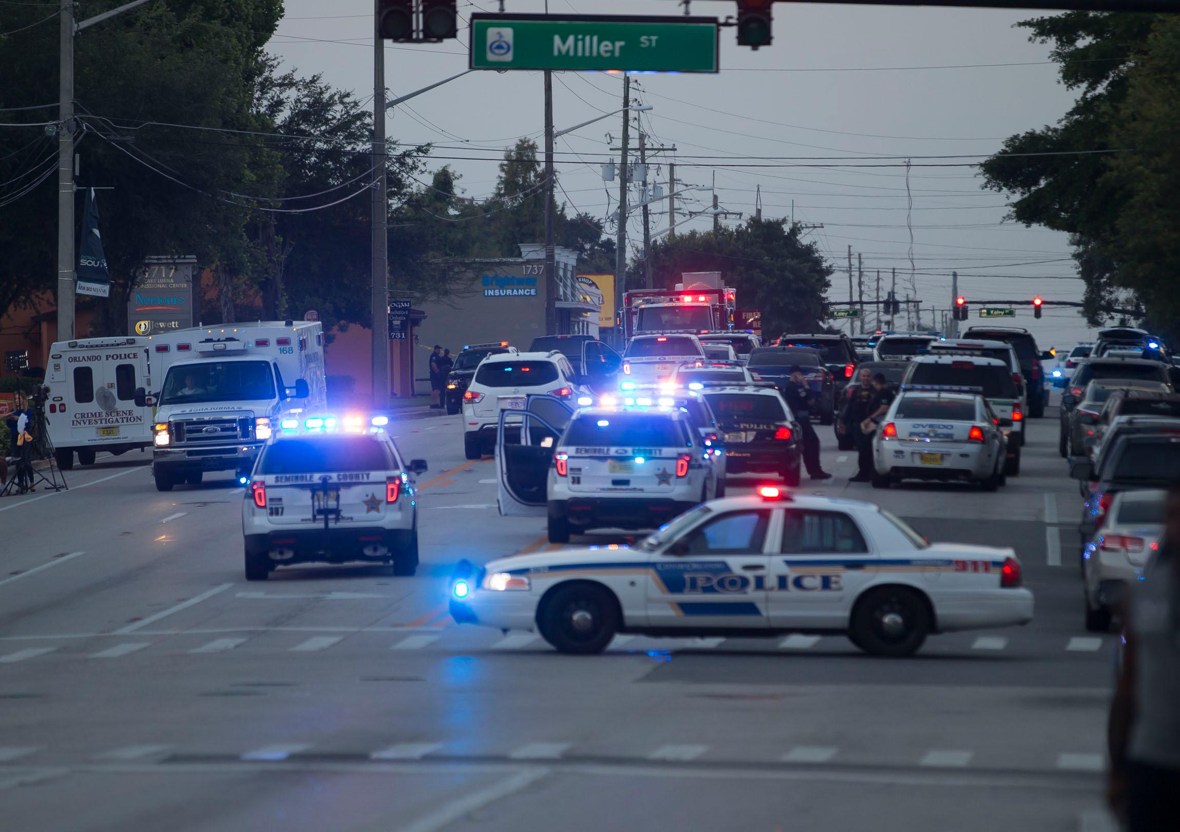 Orlando mass shooting at Pulse nightclub. Police block roads, people wait at hospital.