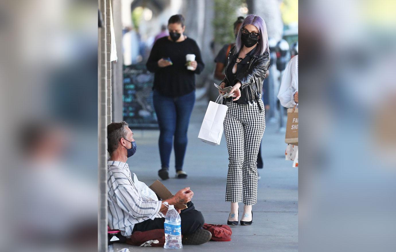 kelly osbourne is seen giving a homeless man some cash while she is out shopping