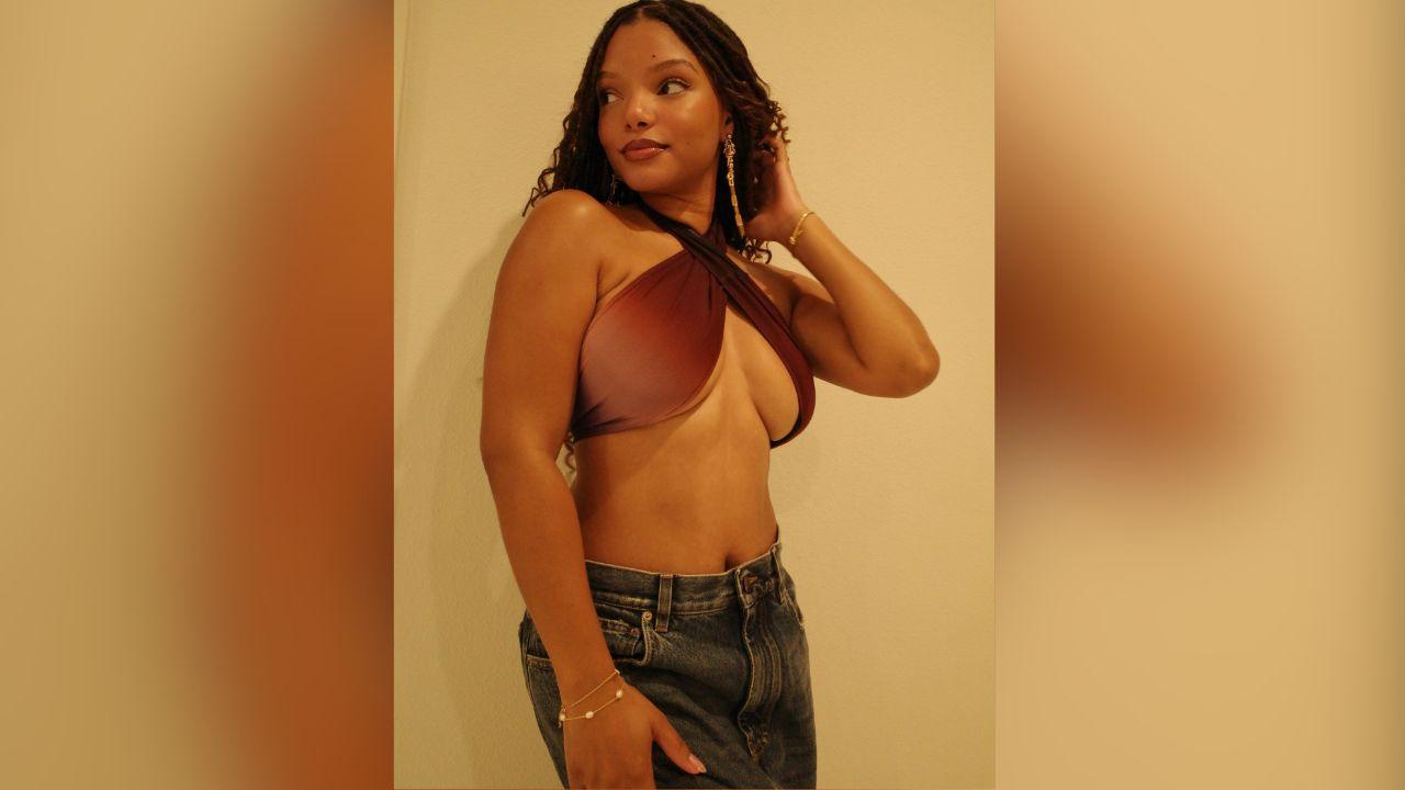 Image of The singer paired her revealing crisscross top with low-rise blue jeans and gold jewelry.