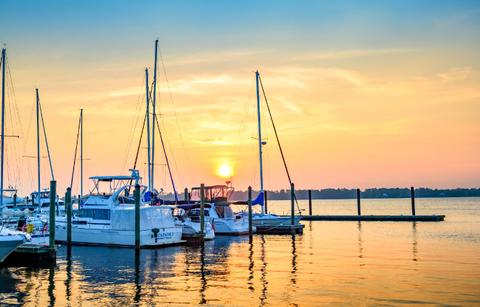 boats on new bern waterfront with orange pink sky in background wide view