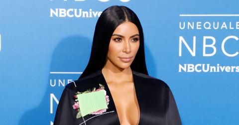 Kim Kardashian wears a lowcut black top that shows off cleavage, with hair black and long and parted in the middle in this 2017 photo taken at the NBCUniversal Upfronts.