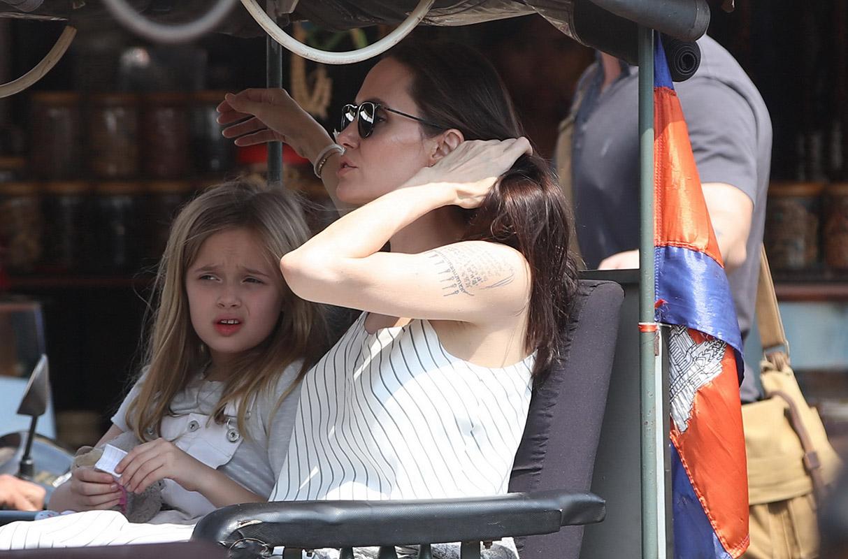 Angelina Jolie is all smiles as she steps out in Cambodia with a handsome mystery man, who has also been bonding with her six young children and buying her jewelry.