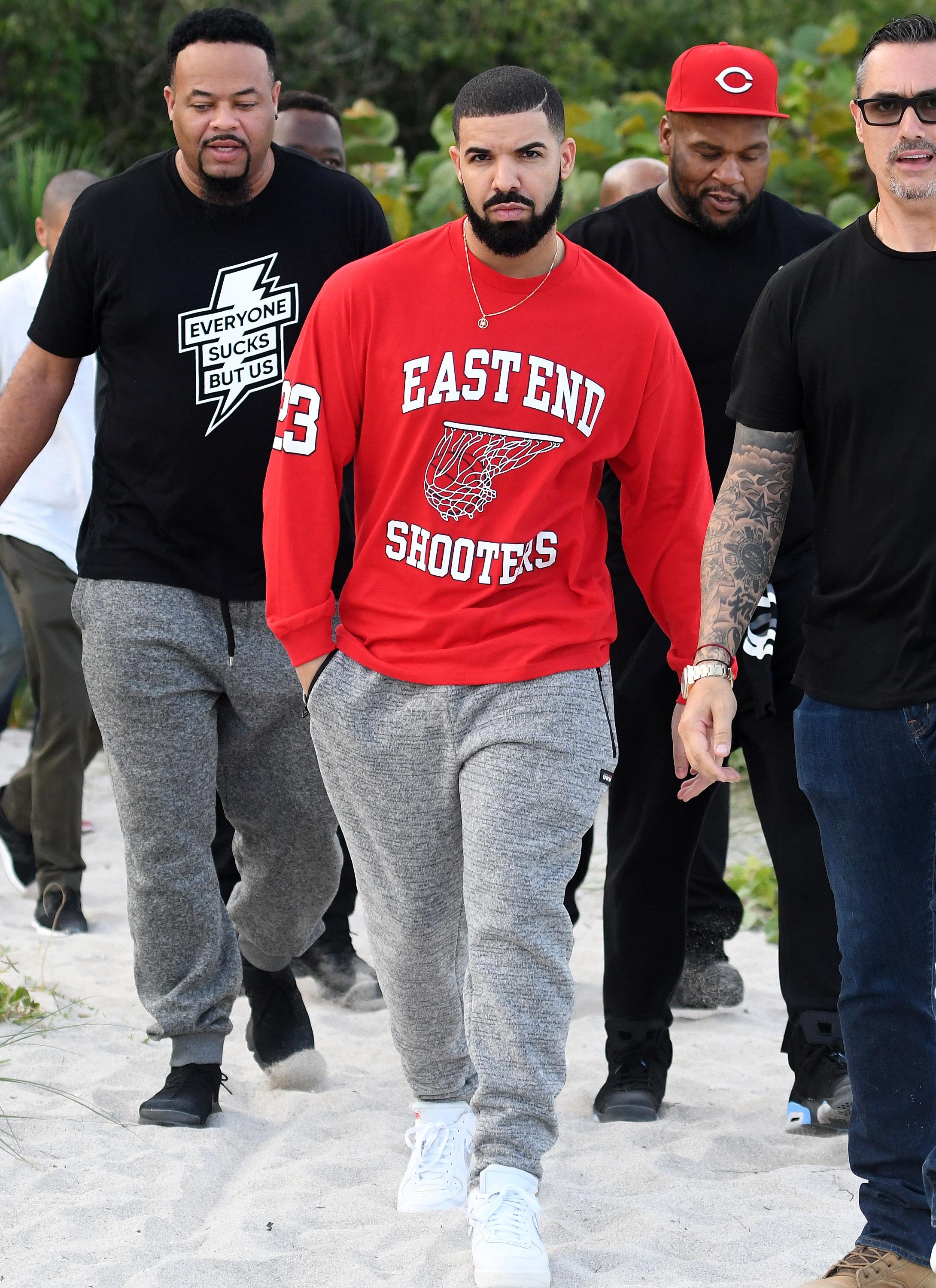 Rapper Drake and his entourage take a walk on the beach before his Art Basel performance in Miami