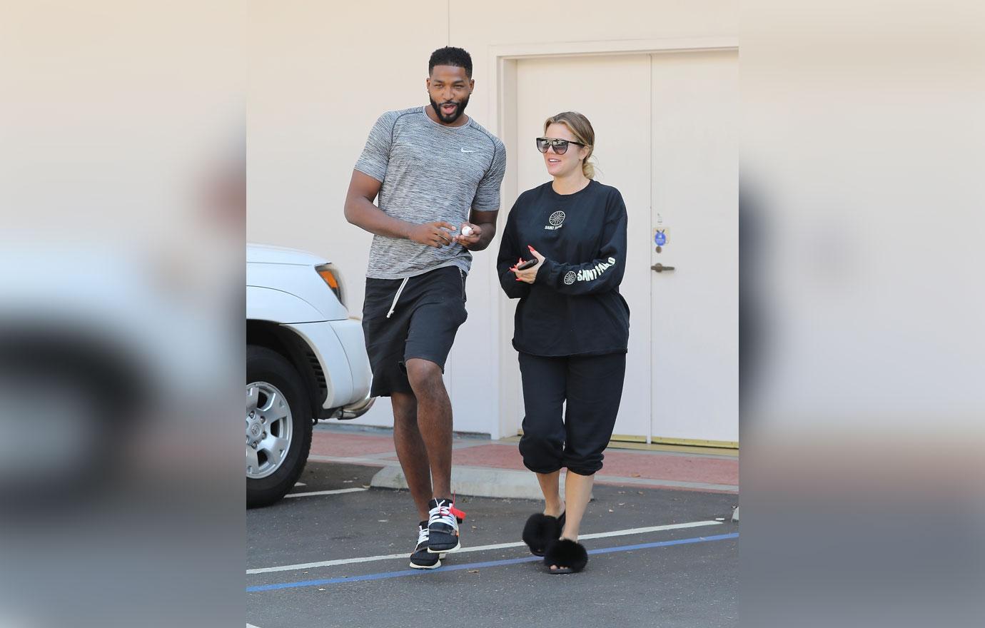 A barefaced Khloe Kardashian stops to take a photo with a fan after a laser session