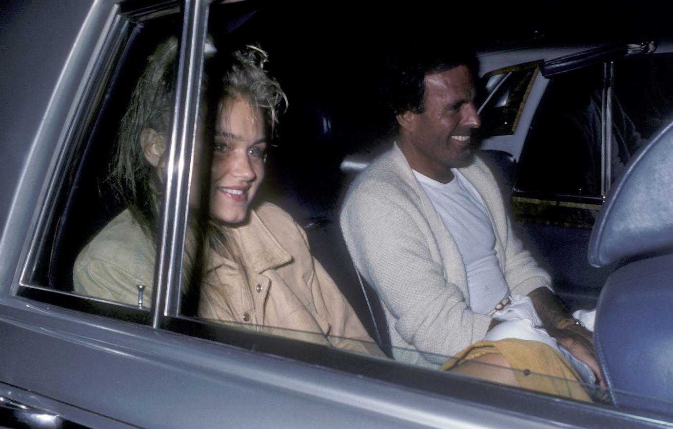 Yolanda Hadid wears a tan coat while on a date with singer Julio Iglesias, who is dressed in white, in 1986 in New York City.