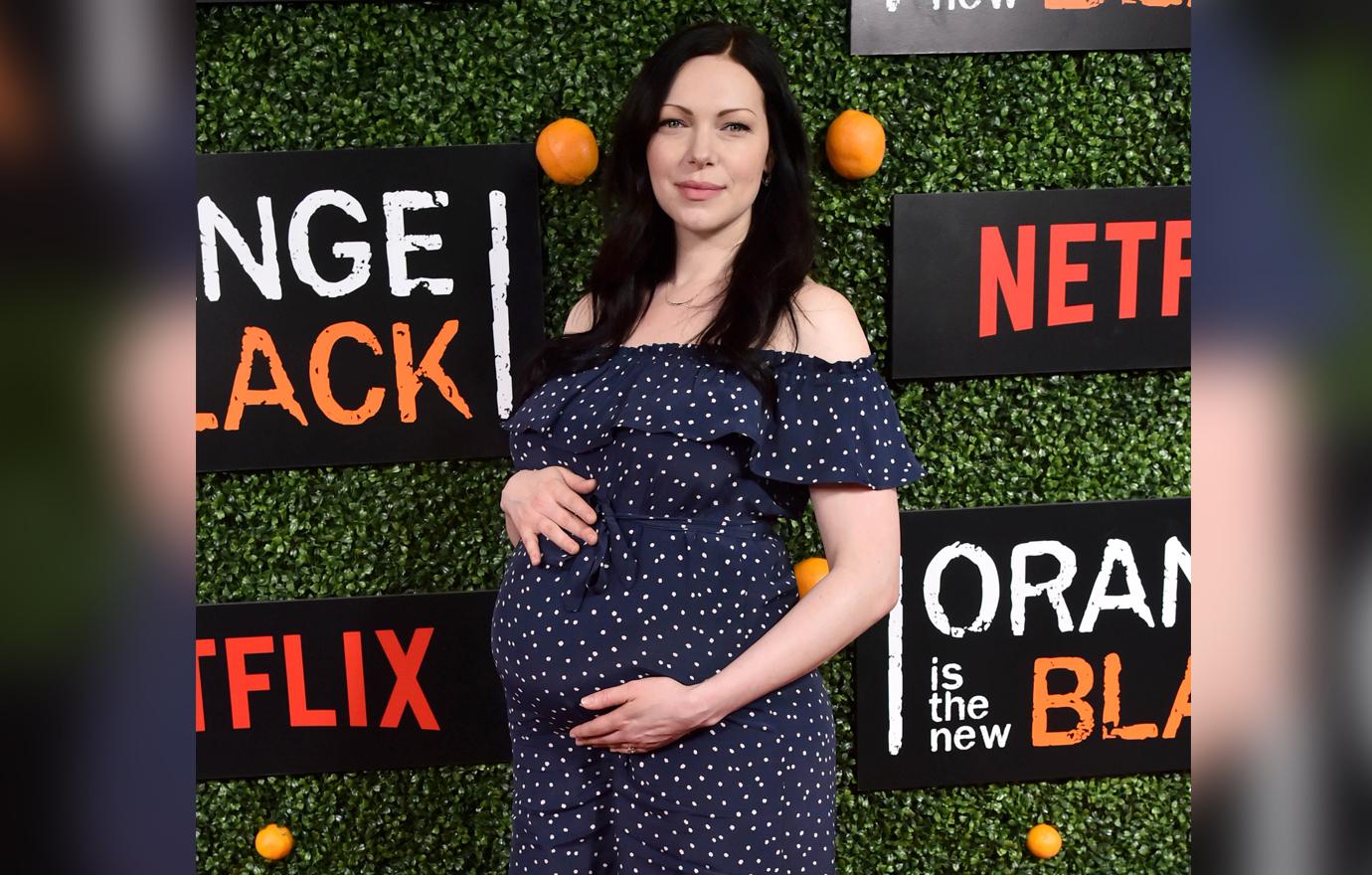 A heavily pregnant Laura Prepon wears a dotted blue dress while on the red carpet.