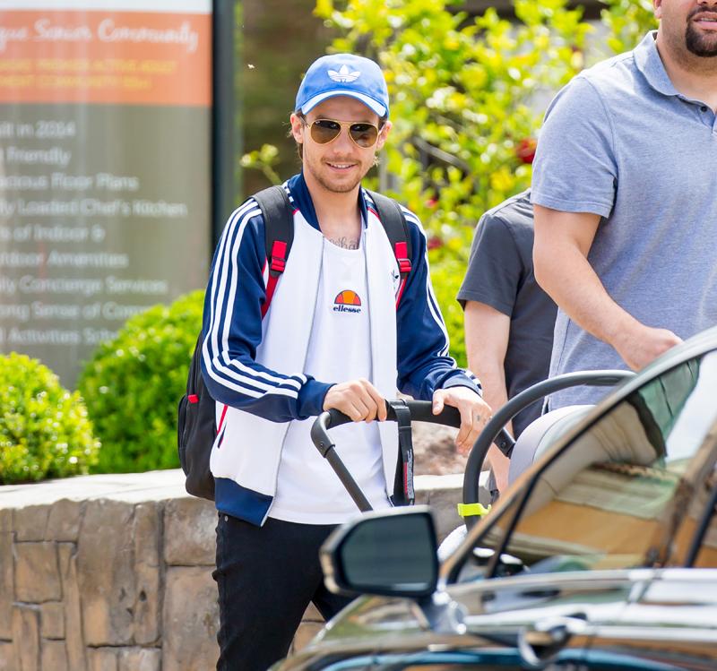 Louis Tomlinson smiles as he takes his son Freddie Reign for an afternoon stroll in Los Angeles, CA