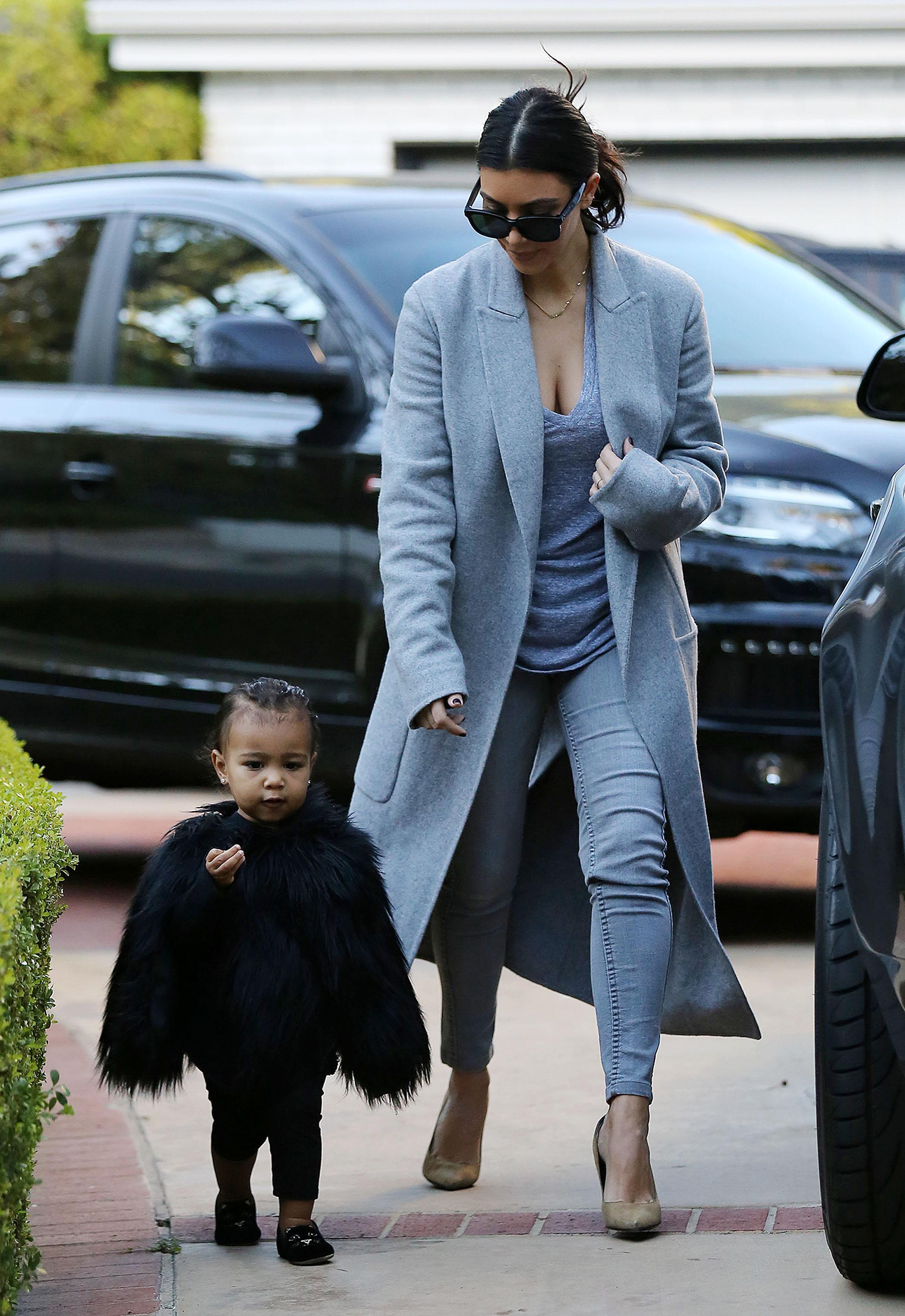 Kim Kardashian and her baby North, dressed in a black fur cape, arriving at a friend&#8217;s house in Beverly Hills ****NO DAILY MAIL SALES****