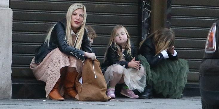 Tori Spelling waiting for taxi in Paris with kids