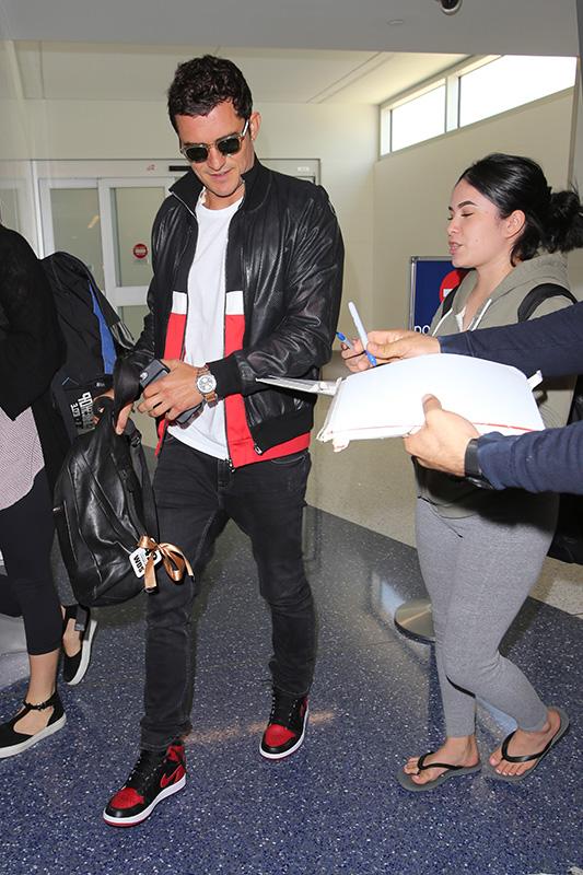 Orlando Bloom signs autographs arriving at LAX