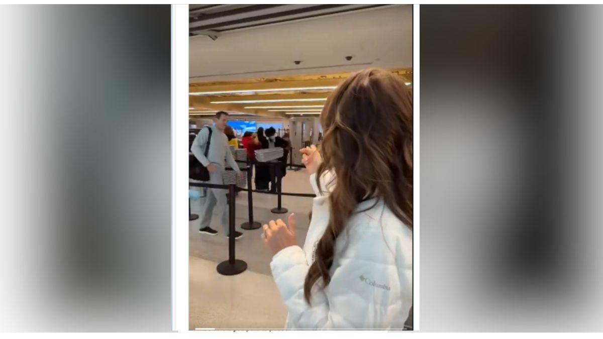 Image of DHS Secretary Kristi Noem pointed to her husband as he checked in for his flight.