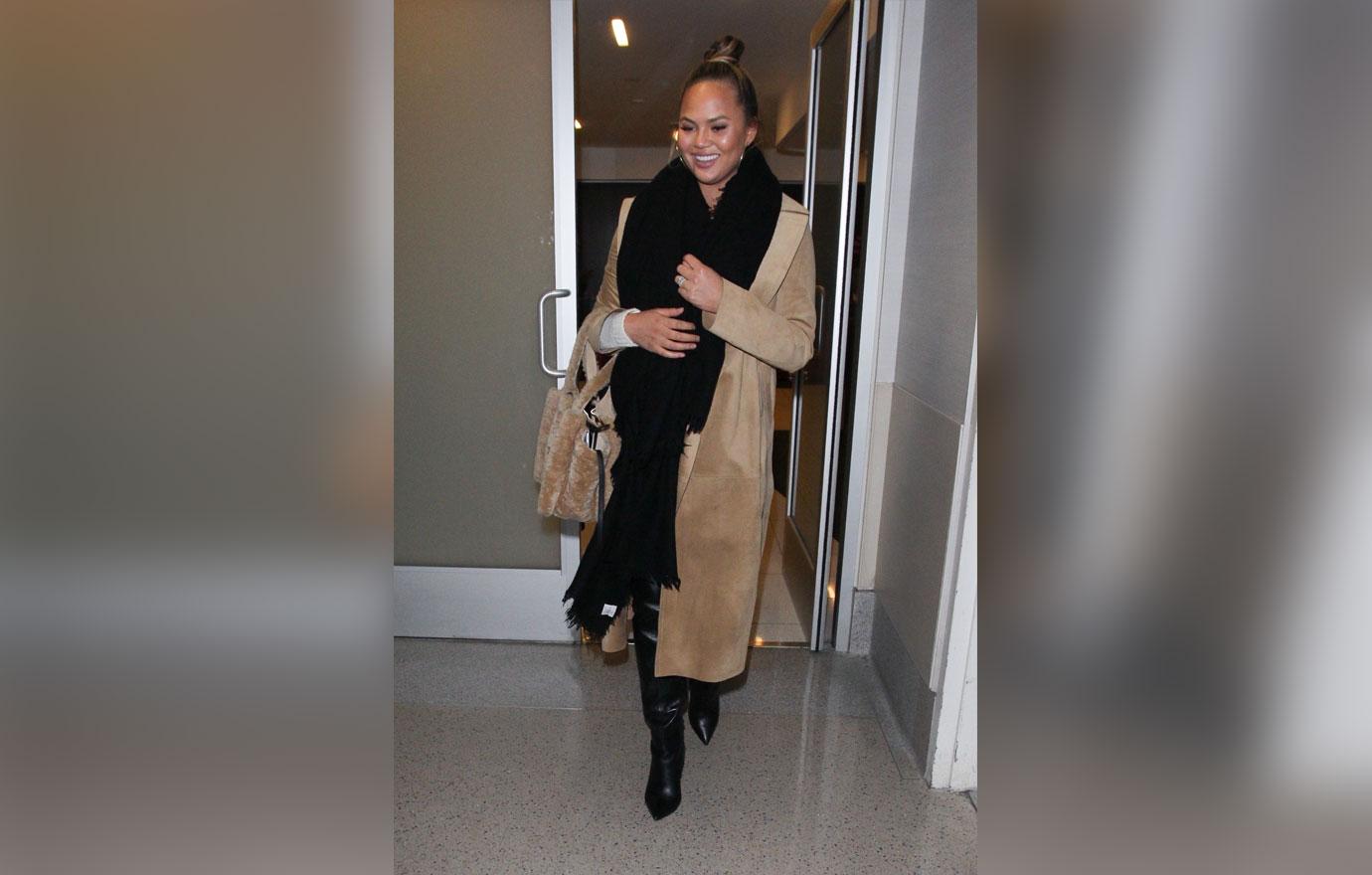 Chrissy Teigen warms up as she dashes to her flight